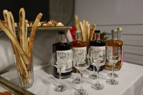 Sto sa čašama i ukusnim štapićima, pripremljeno za uživanje u Reina likerima.